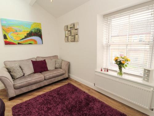 a living room with a couch and a window at Lakes View Apartment 3 in Carnforth