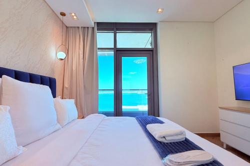 a bedroom with a bed with a view of the ocean at Blue Seaview 75 inch Smart TV 1Br in Manama