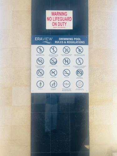 a sign on a wall that says no lifeguard on duty at Blue Seaview 75 inch Smart TV 1Br in Manama