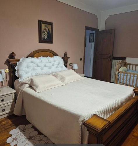 a bedroom with a large bed with white sheets at A COLLODI IO & MAMMA100 m dal Parco di Pinocchio in Collodi