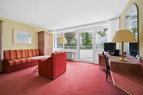 - un salon avec un canapé et un bureau avec un ordinateur dans l'établissement Schwarzwaldapartment Nr 14 40qm Zwei Einzel Betten Rustikal, à Altensteig