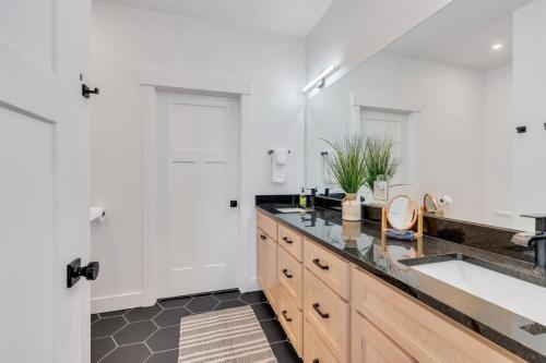 une salle de bain avec un lavabo et un grand miroir dans l'établissement Dream Bear Lake Getaway w/ Hot Tub & Yard, à Garden City