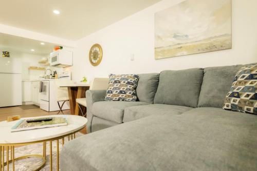 a living room with a gray couch and a table at The Minimalist Escape - Modern 1BD in the Heights in Peoria Heights