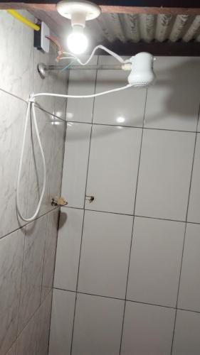 a bathroom with a shower with a light on the wall at Casa aconchegante no distrito Sobradinho de Minas in São Thomé das Letras