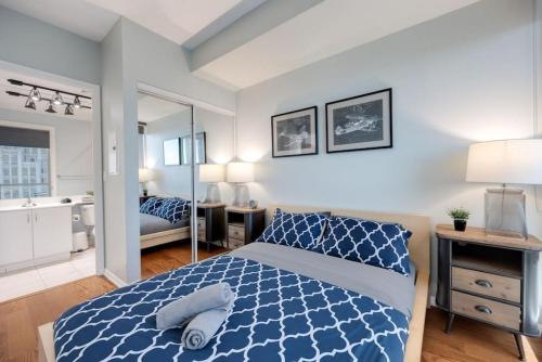 a bedroom with a blue and white bed and a mirror at Ent District 3 Bedroom 2Bath Parking CN Tower in Toronto