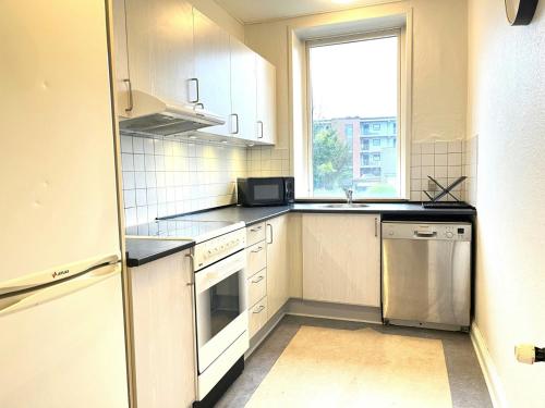 una cocina con electrodomésticos blancos y una ventana en Spacious Apartment for 6, en Frederikshavn
