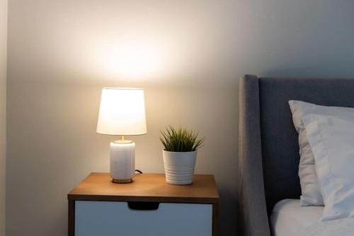 a table with a lamp and a plant on it next to a bed at Ent District 3 Bedroom 2Bath Parking CN Tower in Toronto