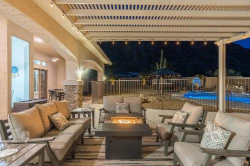 an outdoor patio with couches and a fire pit at 4BR Mesa Mountainside Retreat with Pool, Hot Tub and Games in Mesa