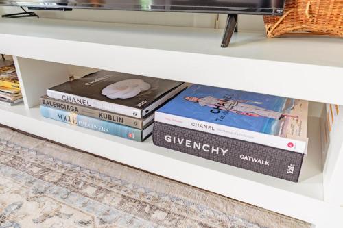 a stack of books sitting on a white shelf at Penthouse Apartment in Stowe in Stowe