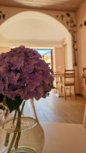 a vase filled with purple flowers sitting on a table at Foresteria Villa Simona in Colico
