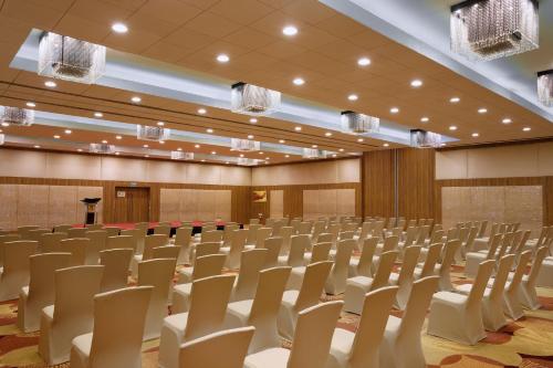 an empty conference room with chairs and a podium at Holiday Inn Cochin by IHG in Cochin
