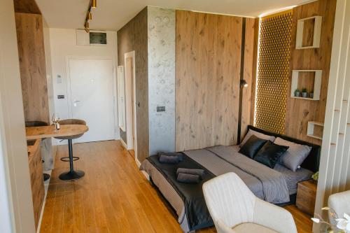 a bedroom with a bed and a desk and a table at Luna Residence in Niš