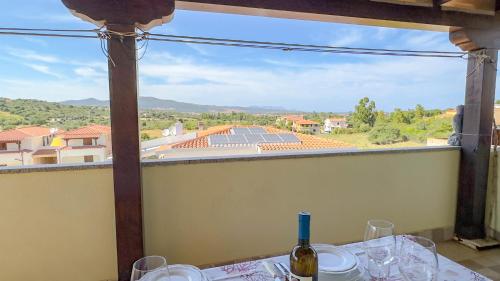 a table with wine glasses and a view from a window at Casa Tombolini in Limpiddu