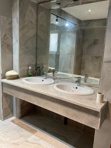 a bathroom with two sinks and a large mirror at Villa de jasmine hammamet in Hammamet Nord