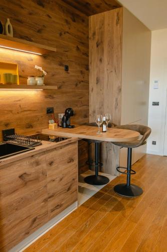 a kitchen with wooden walls and a wooden table at Luna Residence in Niš