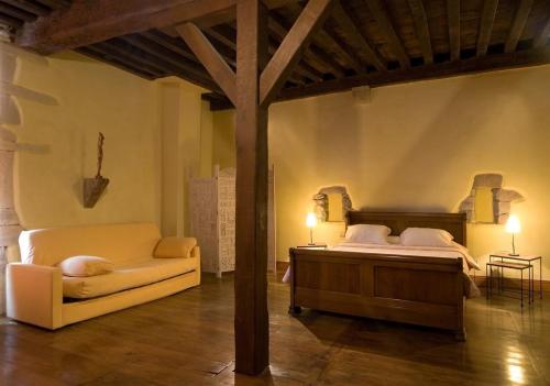 サン・テティエンヌ・ド・バイゴリにあるChambres d'Hôtes Jauregiaのベッドルーム1室(ベッド1台、ソファ付)