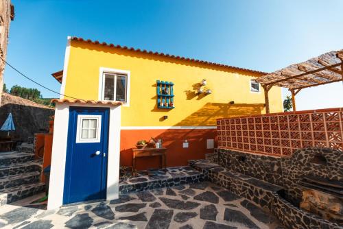 a colorful house with a blue door in front at Casa Águas de Xisto in Gestosa Fundeira