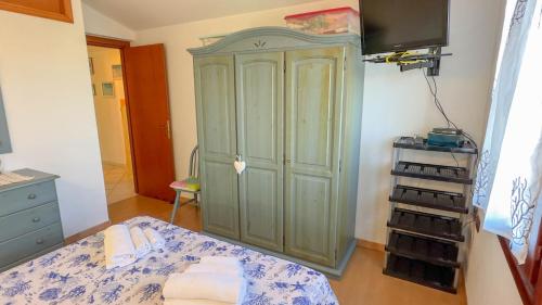 a bedroom with a green cabinet in a room at Casa Tombolini in Limpiddu