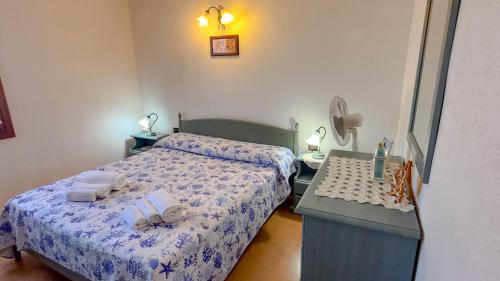 a bedroom with two beds and a table with towels at Casa Tombolini in Limpiddu