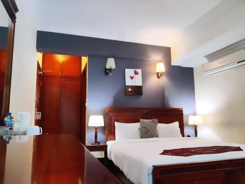 a bedroom with a large bed and a blue wall at Hotel Nikko Towers in Dar es Salaam