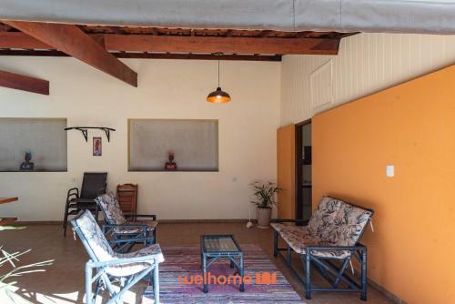 a living room with three chairs and a table at Chácara em São Pedro com piscina e churrasqueira in São Pedro