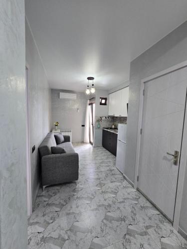 a living room with a couch and a kitchen at Batumi Bliss Panoramic Views in Batumi