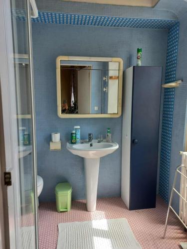 une salle de bain avec un lavabo et un miroir dans l'établissement Au pied de la Cathédrale, à Bayeux