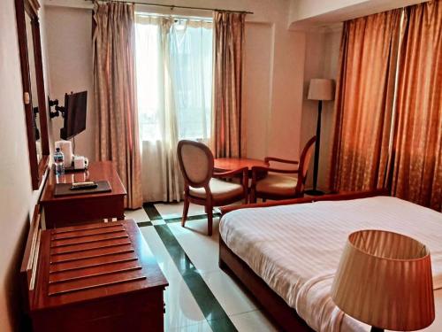 a hotel room with a bed and a desk at Hotel Nikko Towers in Dar es Salaam