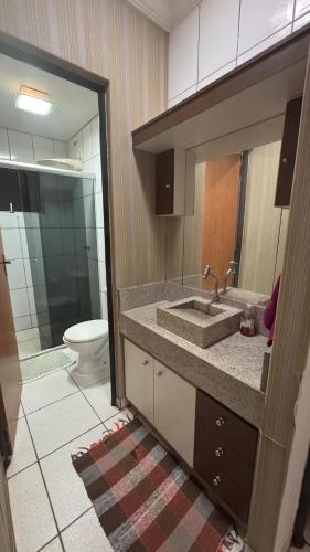a bathroom with a sink and a toilet at Apto Aconchegante Araguari MG in Araguari