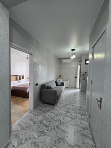 a living room with a couch and a bed in a room at Batumi Bliss Panoramic Views in Batumi