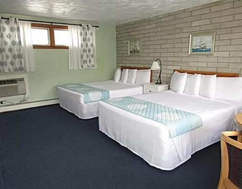 a hotel room with two beds and a window at Blue Sea Motor Inn in North Truro