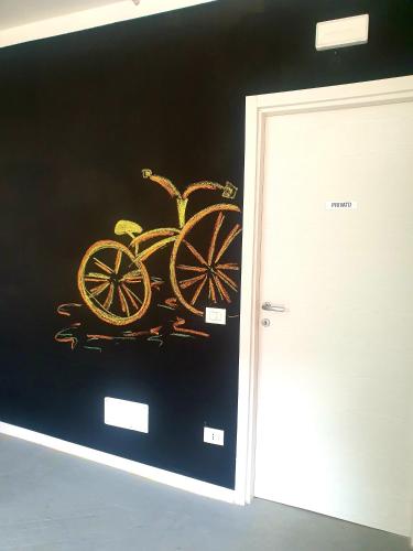 a painting of a carriage on a wall next to a door at Dolcevita guest house in Torreano