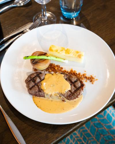 a white plate with a steak and other food on a table at Bicester Hotel, Golf & Spa in Bicester