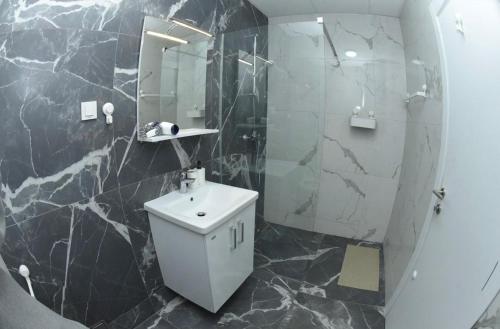 e bagno con servizi igienici bianchi e doccia. di 22 House a Skopje