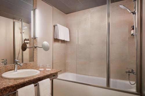 a bathroom with a sink and a shower at NH Collection Heidelberg in Heidelberg