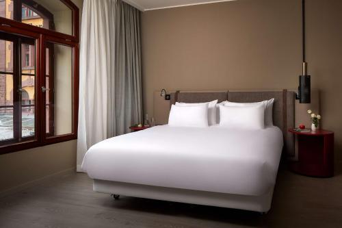 a large white bed in a hotel room at NH Collection Heidelberg in Heidelberg