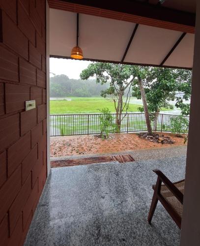 a door to a porch with a view of a field at Nellu - Tranquil Pool Villa & Organic Farmstay near Varkala in Trivandrum