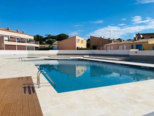a swimming pool with blue water in a building at Pavillon 4-6 couchages in Cap d'Agde