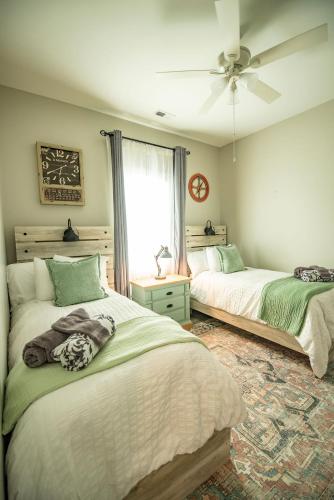 a bedroom with two beds and a ceiling fan at Private Soundside Home In Emerald Isle in Emerald Isle