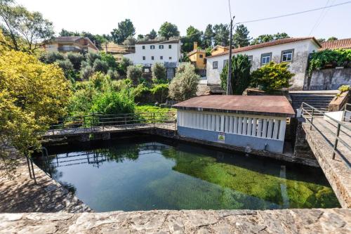 a pool of water in a yard with buildings at Casa Águas de Xisto in Gestosa Fundeira