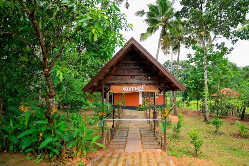 a small building in the middle of a forest at Nellu - Tranquil Pool Villa & Organic Farmstay near Varkala in Trivandrum