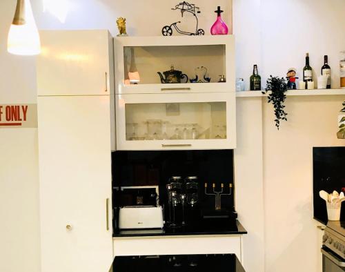 a kitchen with white cabinets with a coffee maker in it at Horizon View Mountain Bliss in Kandy