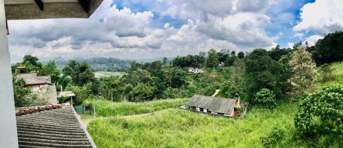 a view of an old house in a green field at Horizon View Mountain Bliss in Kandy