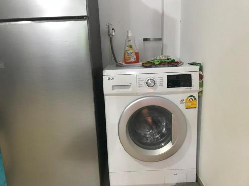 a washing machine in a room with a refrigerator at Horizon View Mountain Bliss in Kandy