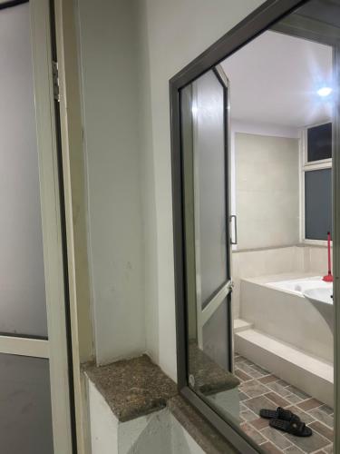 a mirror in a bathroom with a tub and a sink at Bansbari Warm Home in Kathmandu