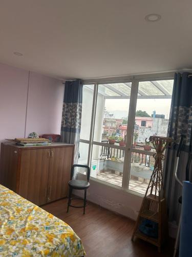 a bedroom with a bed and a window with a balcony at Bansbari Warm Home in Kathmandu