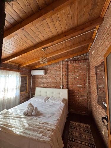 a bedroom with a large bed in a brick wall at Golden Campsite Villas in Berat