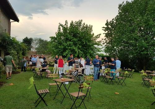 a group of people standing in a yard with tables and chairs at B&B Il Posto delle Rose in Almenno San Salvatore