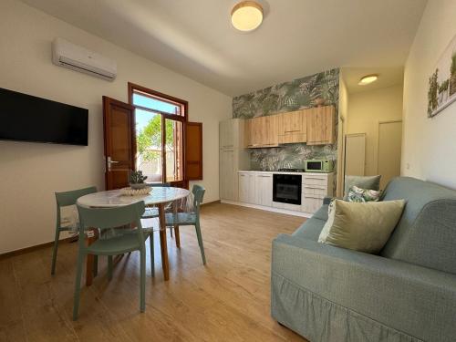 a living room with a table and a blue couch at Appartamento Ciliegio in San Vito lo Capo