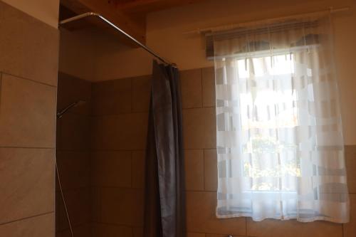 a shower curtain in a bathroom with a window at Il Toscanello in Lido di Camaiore